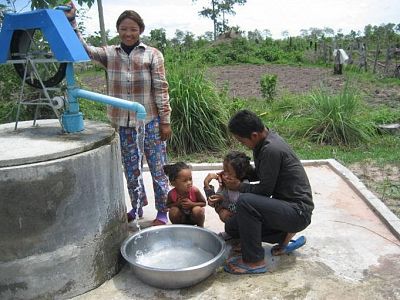 Chhim Savoeun and her husband are putting their hygiene training and knowledge into practice as they use clean water from their well to wash before a meal.