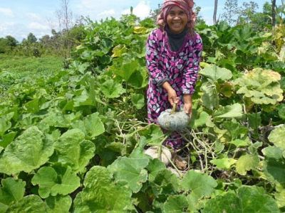 Kanh Mom smiles as she shows off her harvest of plump squash